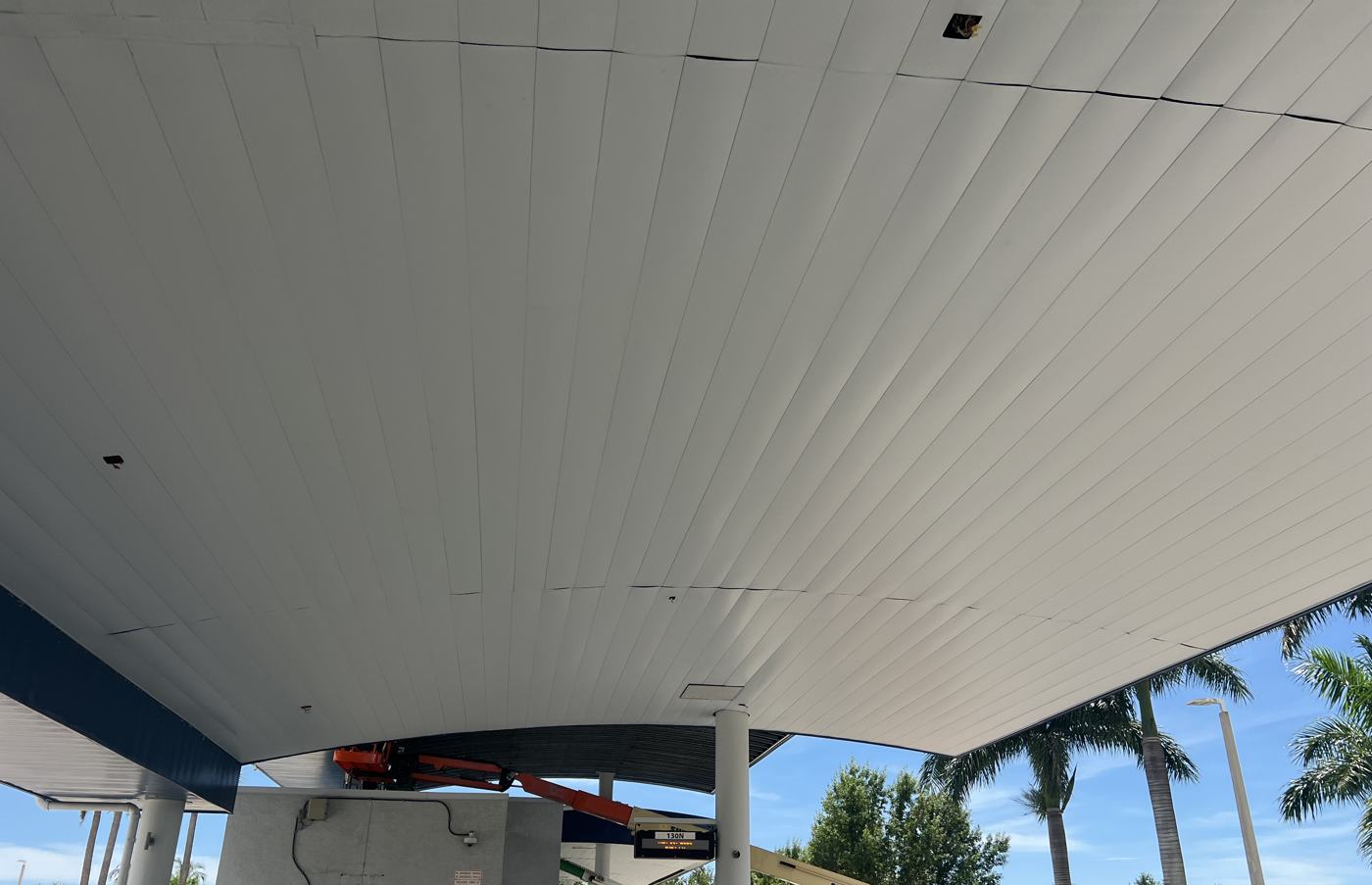 Finished white soffit under the canopy with the bus bay sign lit.